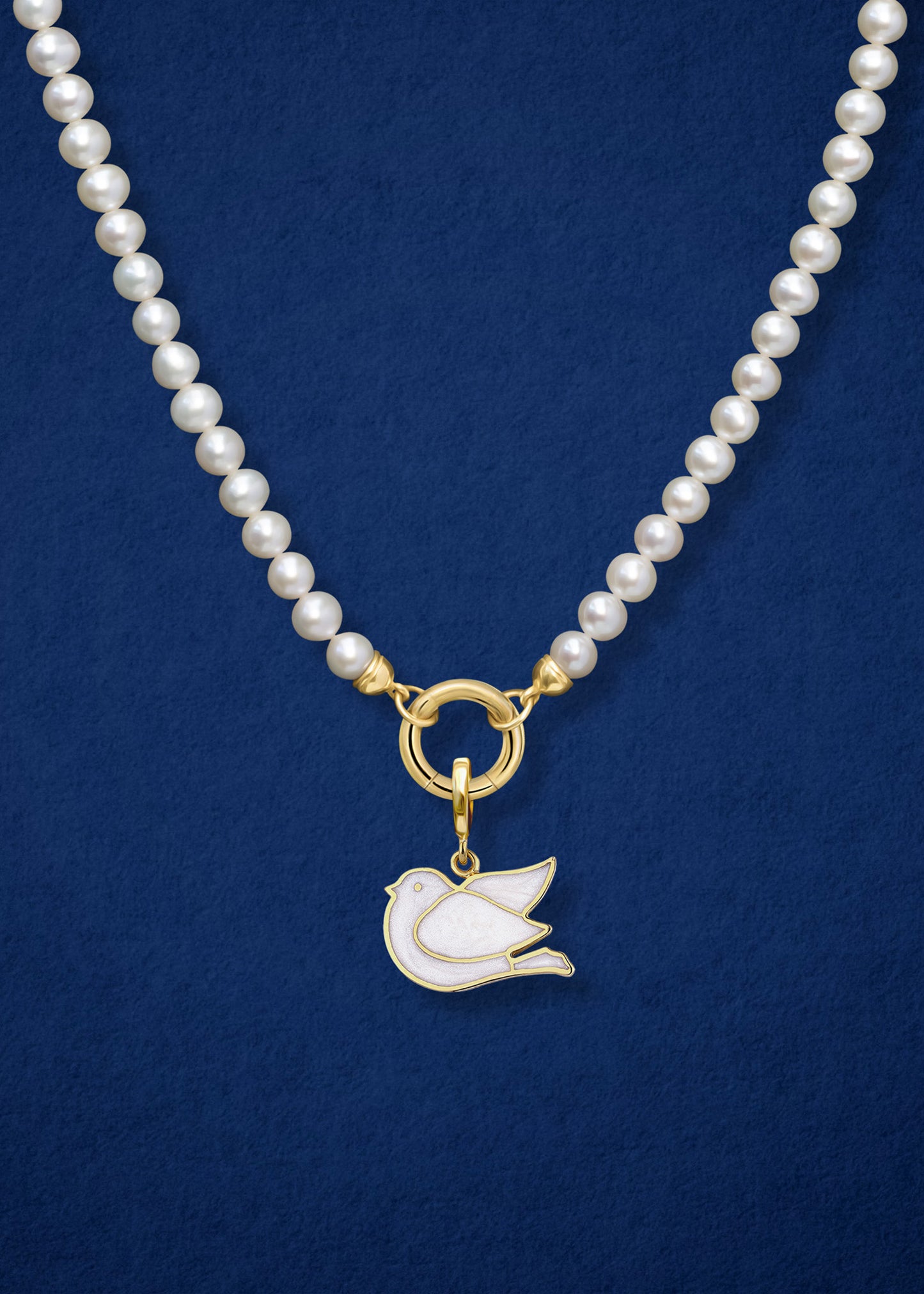 Close-up of the Dove of Hope Charm paired with the Lustrous Pearl Charm Necklace by whywhy NYC, featuring 14K solid gold and freshwater pearls for a graceful and timeless design.