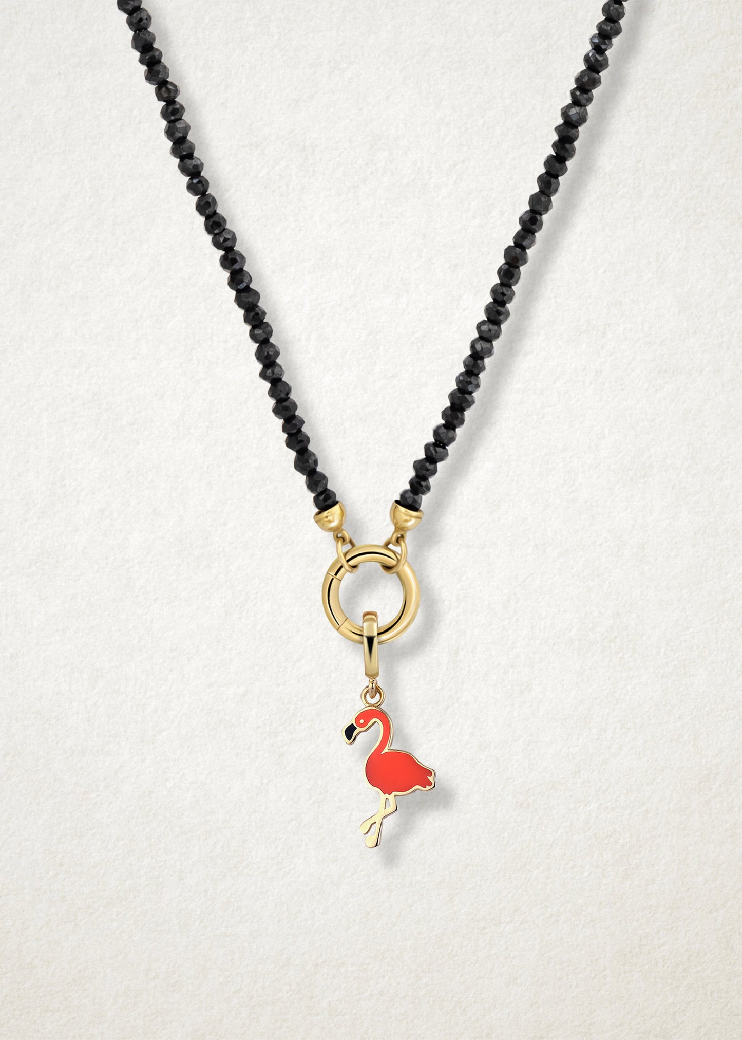 Close-up of the Flamingo Flair Charm paired with the Noir Elegance Charm Necklace by whywhy NYC, featuring black spinel and 14K solid gold for a striking and tropical-inspired look.
