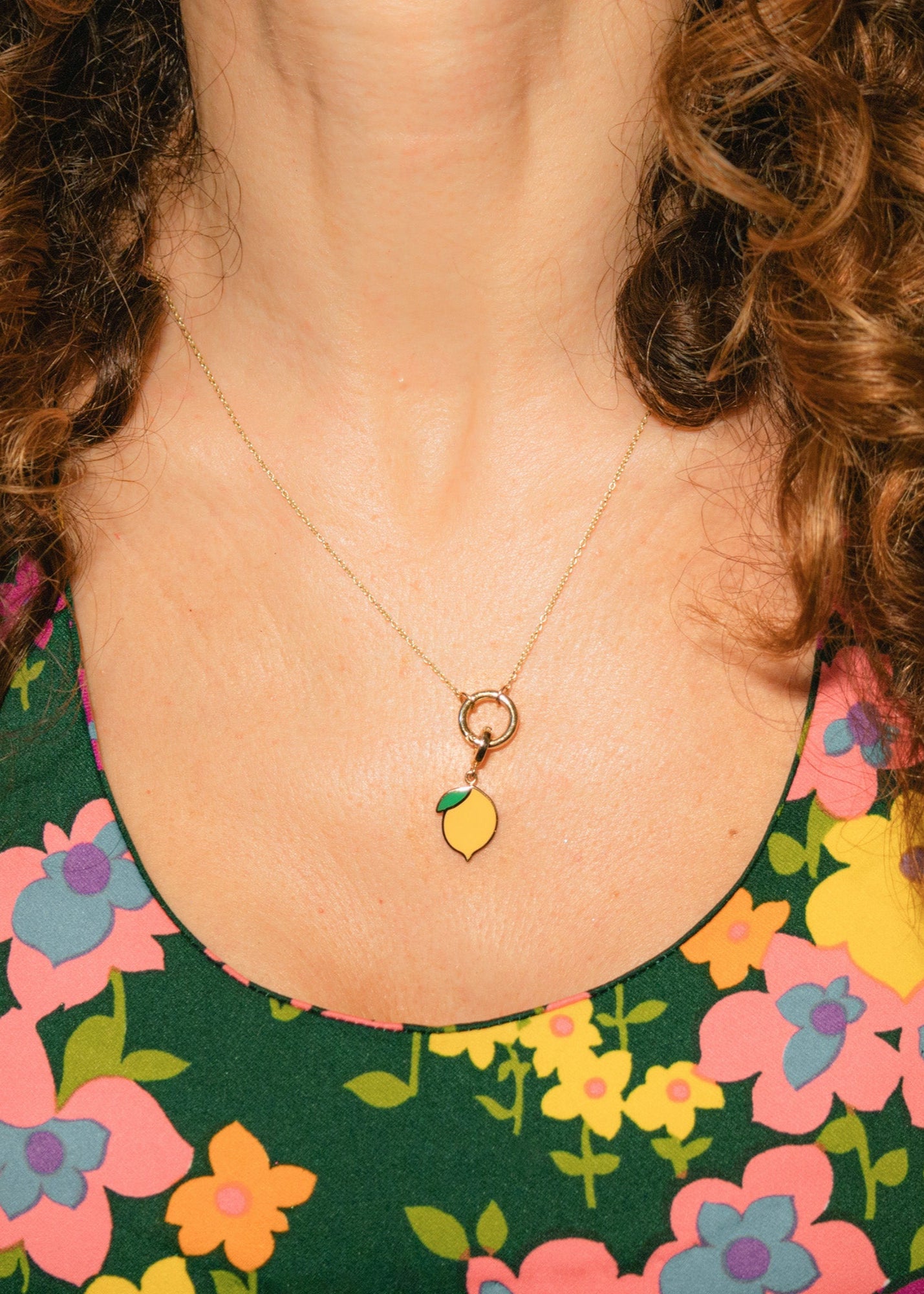 Close-up of the Golden Grace Zesty Lemon Charm Necklace in 14K solid gold, elegantly worn. The vibrant yellow enamel lemon charm adds a playful touch, hanging from a delicate gold chain.