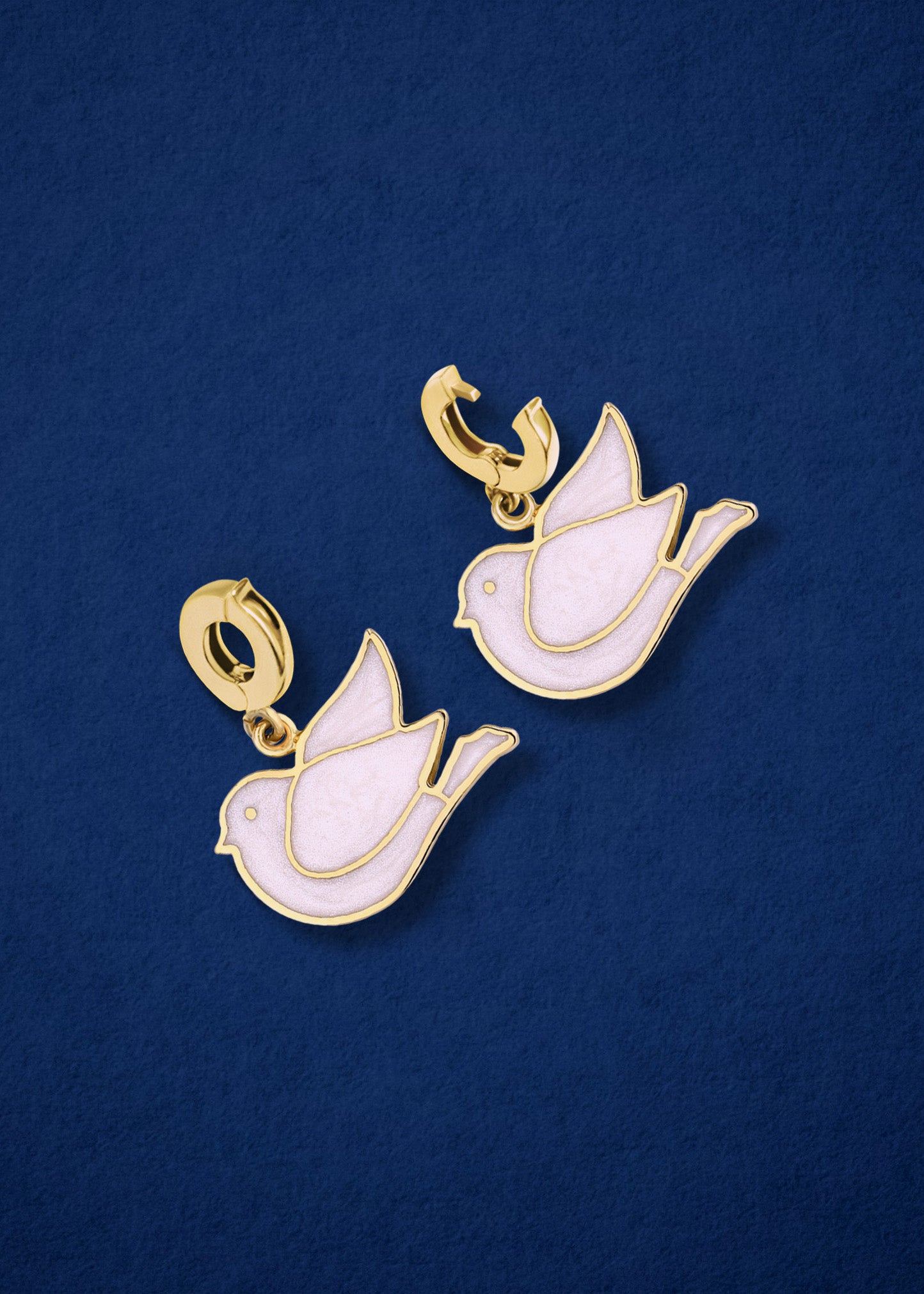 Dove of Hope Charm showing both open and closed views of the 14K solid gold clip, with white enamel, displayed on a midnight blue background.