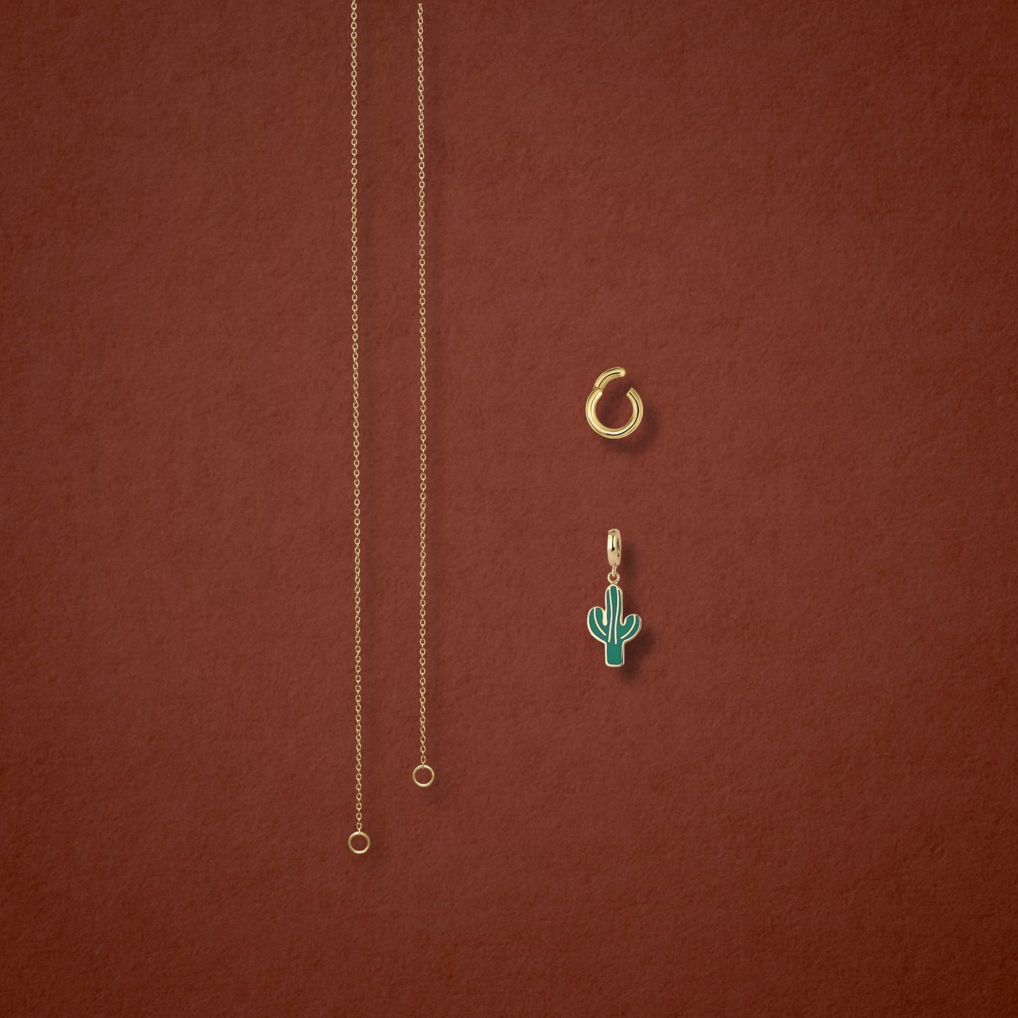 Separated components of the Golden Grace Desert Bloom Charm Necklace, including 14K solid gold cable chain, golden link charm holder, and desert bloom charm with green enamel by whywhy NYC.