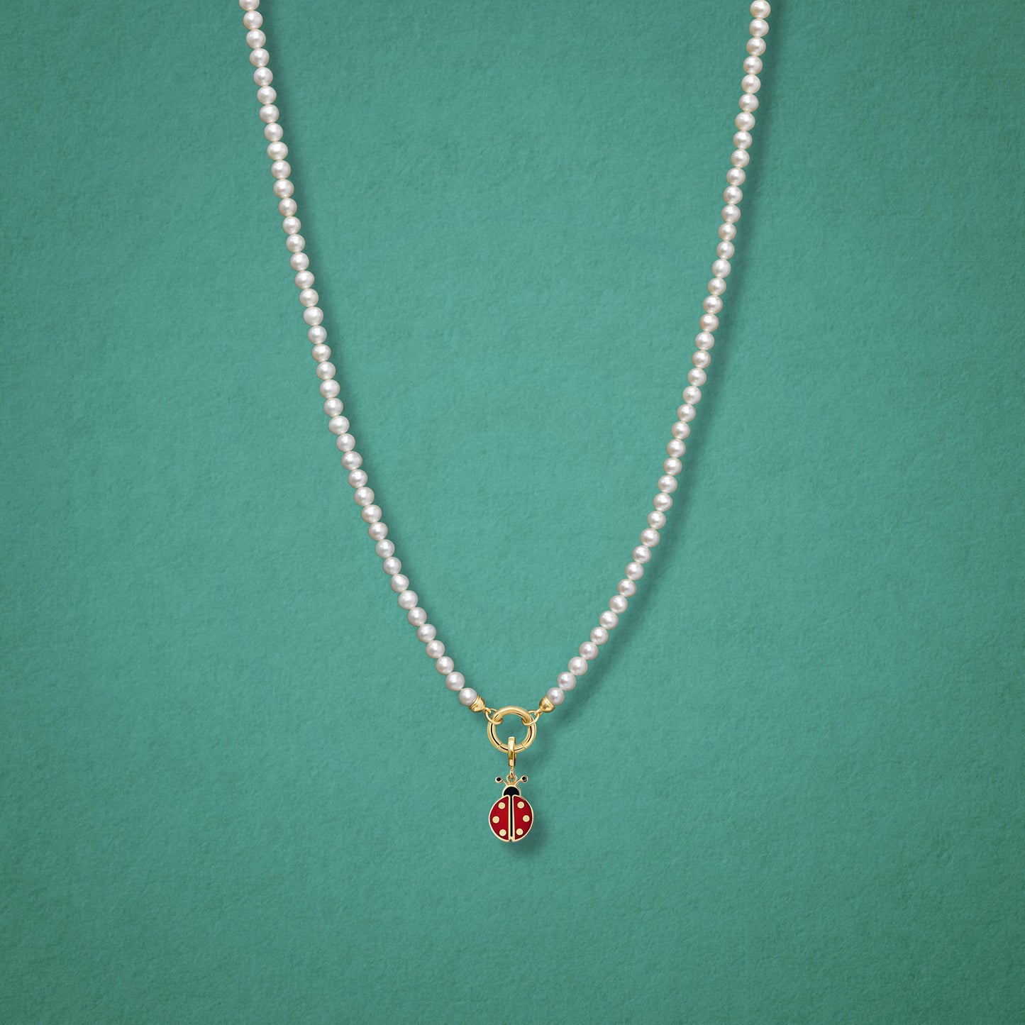 Lucky Ladybird Charm paired with the Lustrous Pearl Charm Necklace by whywhy NYC, featuring 14K solid gold and hand-painted enamel for a playful, elegant look.