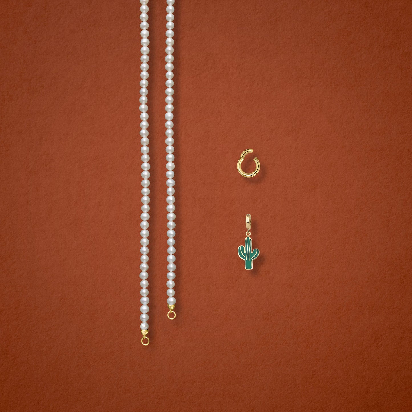 Separated components of the Lustrous Pearl Desert Bloom Charm Necklace, including pearl necklace, charm holder, and desert bloom charm in 14K solid gold by whywhy NYC.