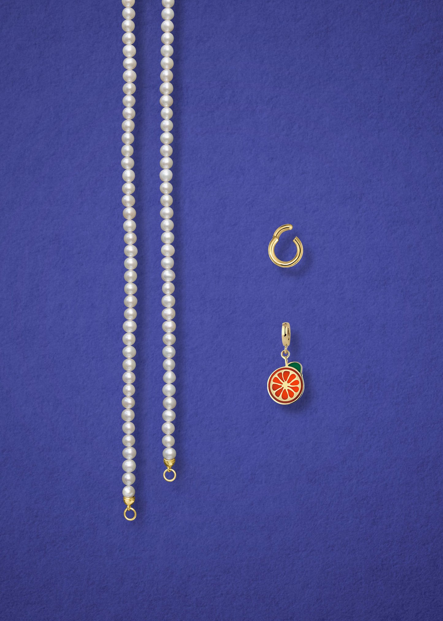 Separated components of the Lustrous Pearl Orange Crush Charm Necklace, including pearl necklace, charm holder, and orange crush charm in 14K solid gold by whywhy NYC.