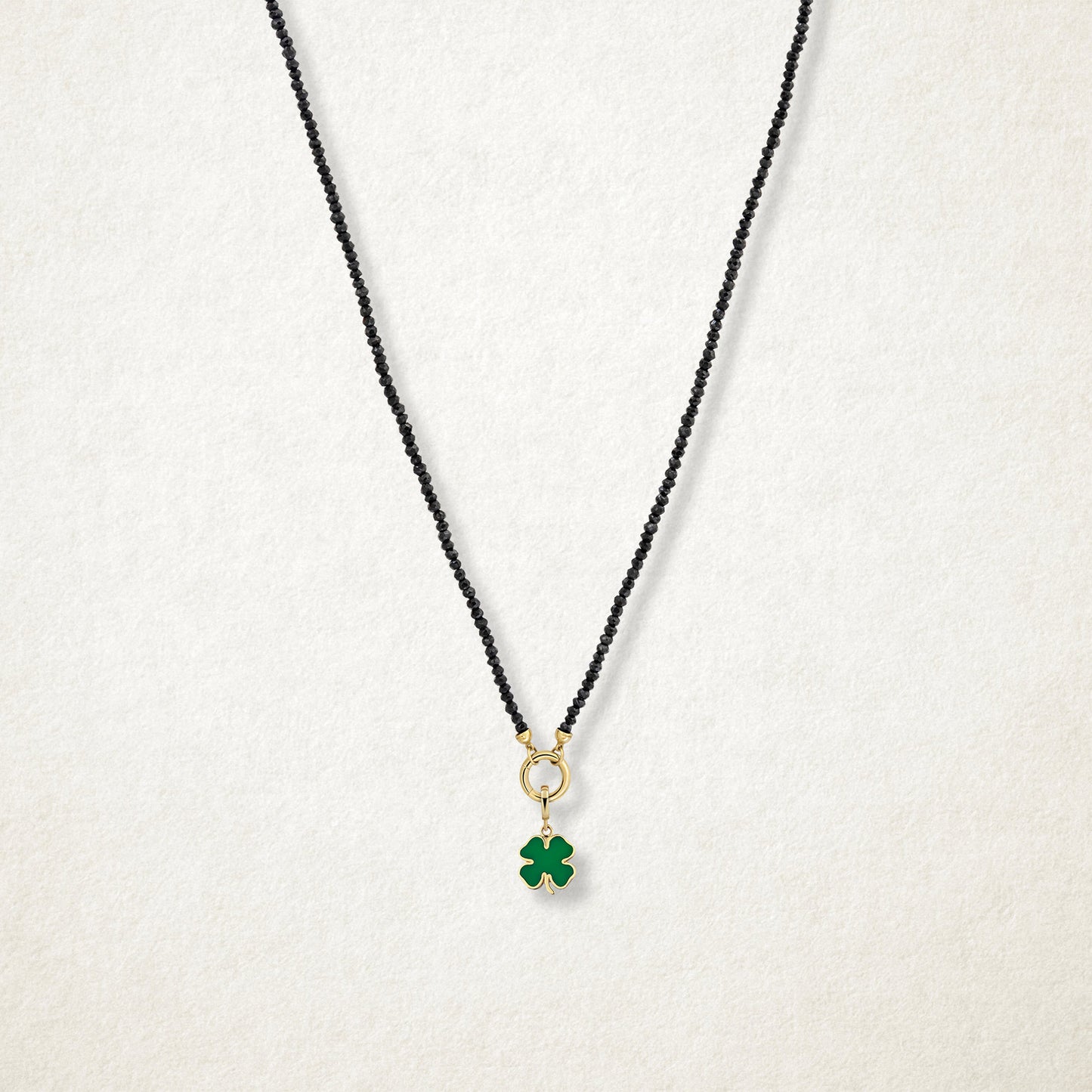 Noir Elegance Lucky Clover Charm Necklace in full view, showcasing faceted black spinel beads, a golden link charm holder, and lucky clover charm with green enamel by whywhy NYC.