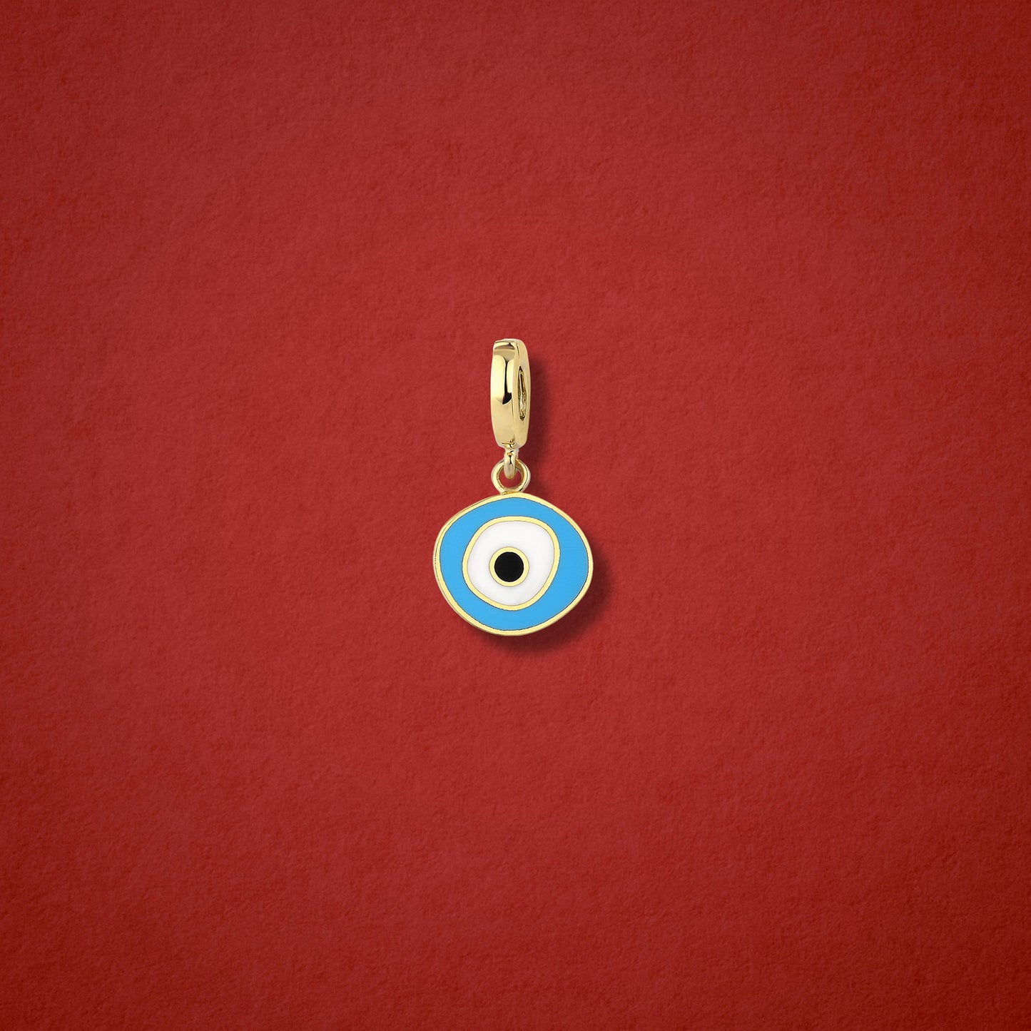Sky Organic Evil Eye clip-on charm crafted in 14K solid gold with hand-painted sky blue, white, and black enamel detailing, shown on a red background.