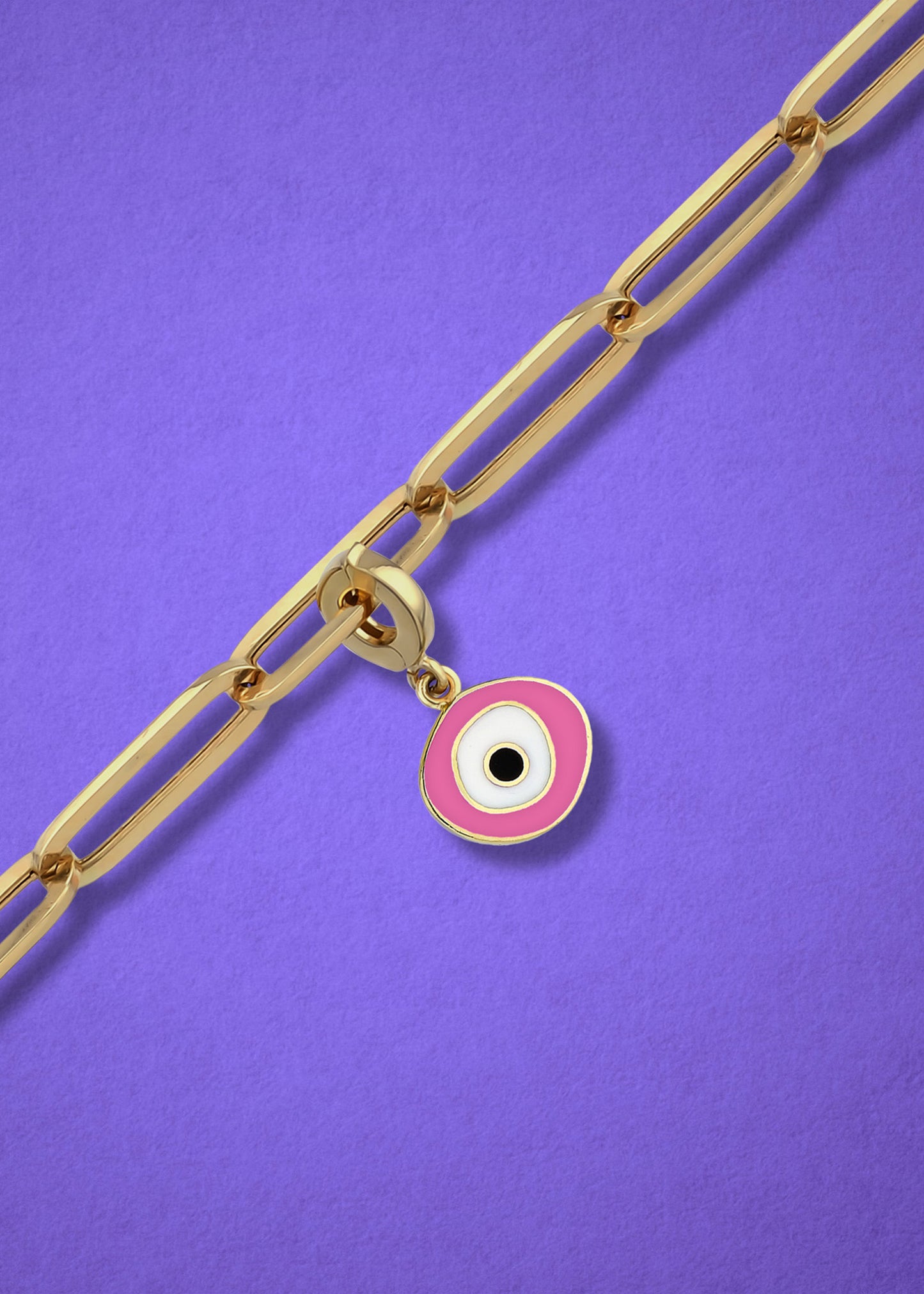 Blush Organic Evil Eye clip-on charm crafted in 14K solid gold with pink, white, and black enamel, shown hanging on a gold chain on a lilac background.