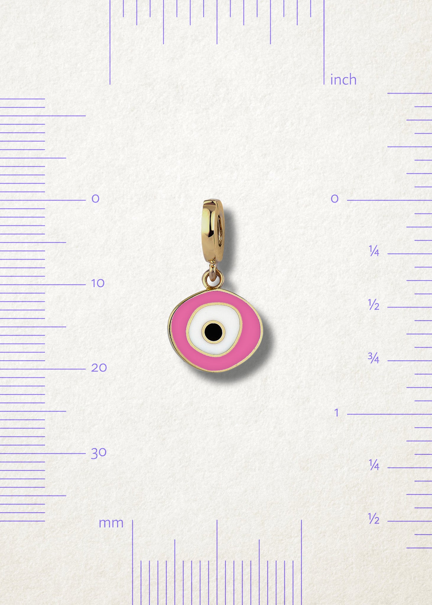 Blush Organic Evil Eye Charm with pink, white, and black enamel displayed beside measurement markers on a soft light background to show its size.