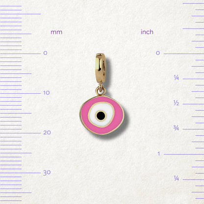 Blush Organic Evil Eye Charm with pink, white, and black enamel displayed beside measurement markers on a soft light background to show its size.