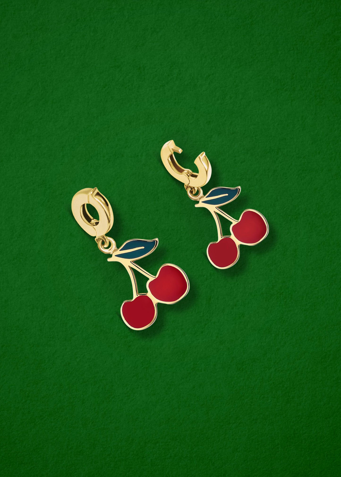 Cherry on Top Charm showing both open and closed views of the 14K solid gold clip, with rich red enamel detailing, displayed on a green background.