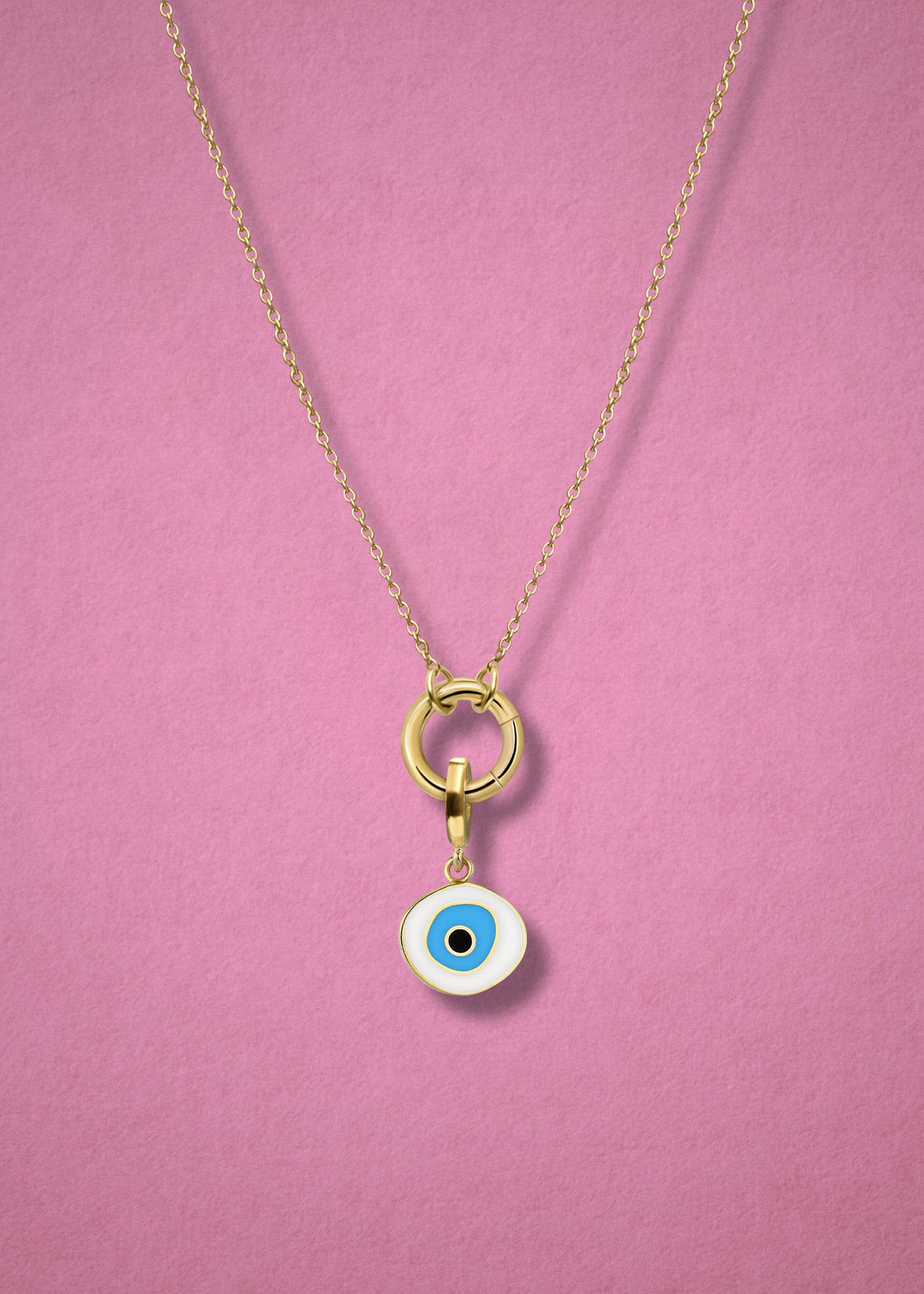 Close-up of the Azure Organic Evil Eye Charm with hand-painted enamel on a 14K solid gold cable chain necklace, shown on a soft pink background.