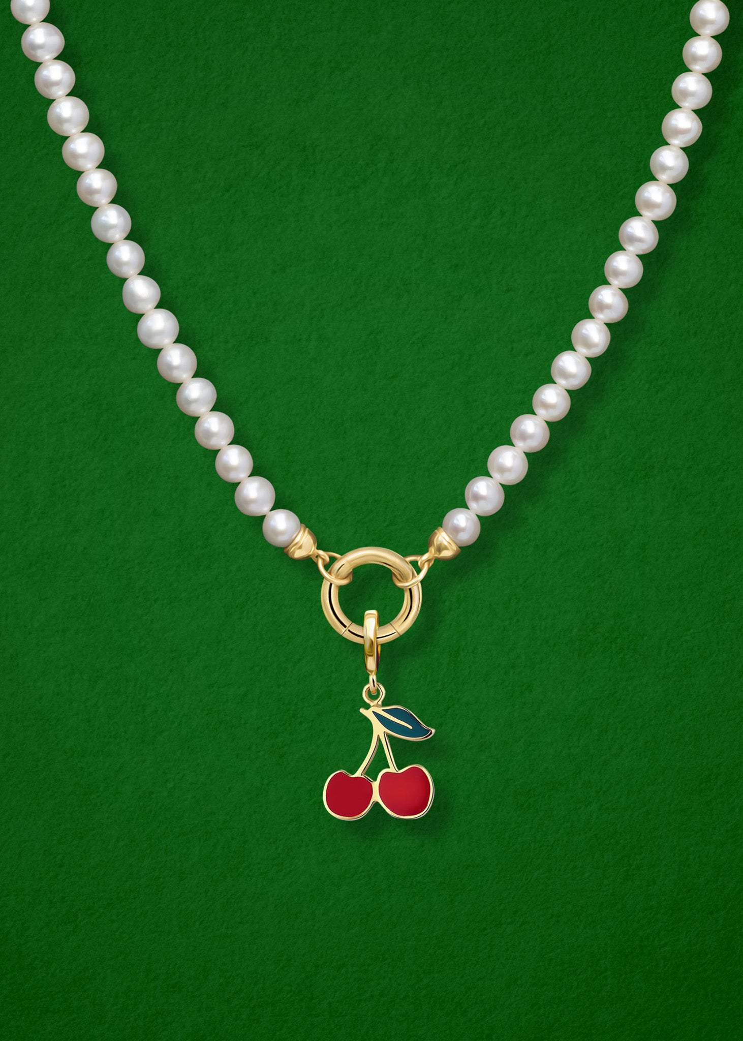 Close-up of the Cherry on Top Charm paired with the Lustrous Pearl Charm Necklace by whywhy NYC, featuring 14K solid gold and freshwater pearls for a whimsical yet elegant look.