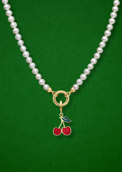 Close-up of the Cherry on Top Charm paired with the Lustrous Pearl Charm Necklace by whywhy NYC, featuring 14K solid gold and freshwater pearls for a whimsical yet elegant look.