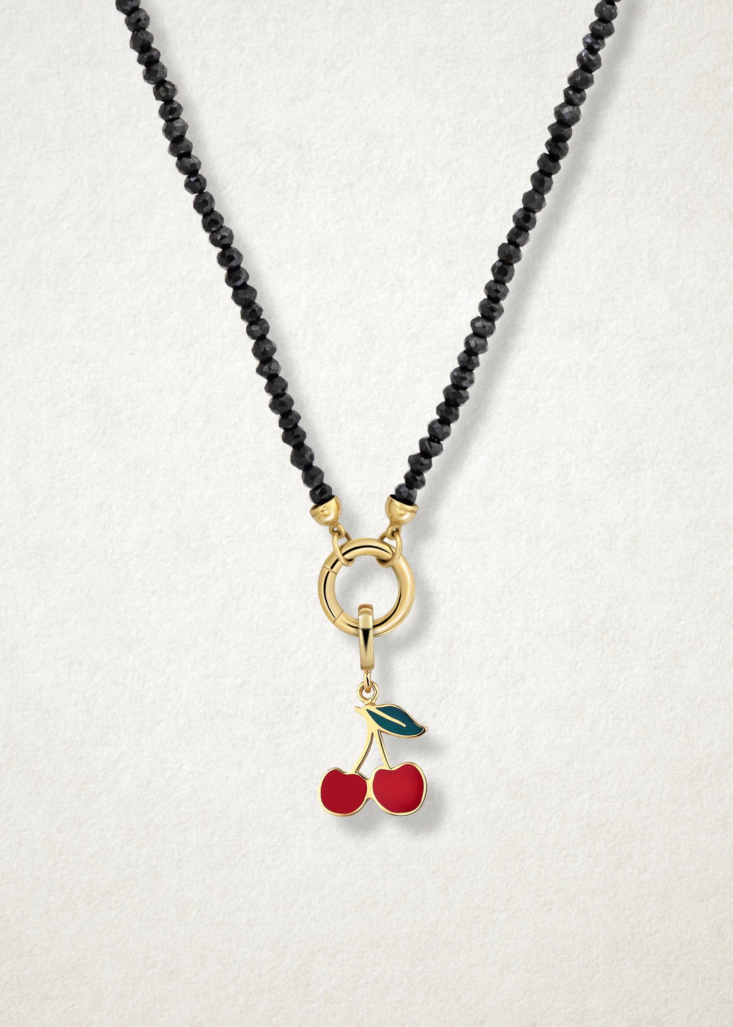 Close-up of the Cherry on Top Charm paired with the Noir Elegance Charm Necklace by whywhy NYC, featuring black spinel and 14K solid gold for a bold and sweet statement.