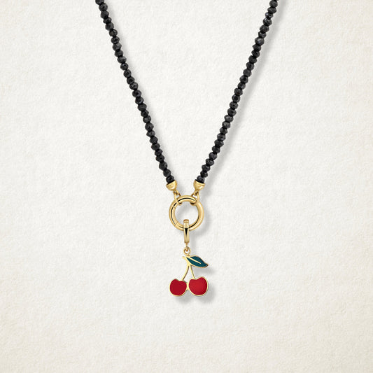 Close-up of the Cherry on Top Charm paired with the Noir Elegance Charm Necklace by whywhy NYC, featuring black spinel and 14K solid gold for a bold and sweet statement.