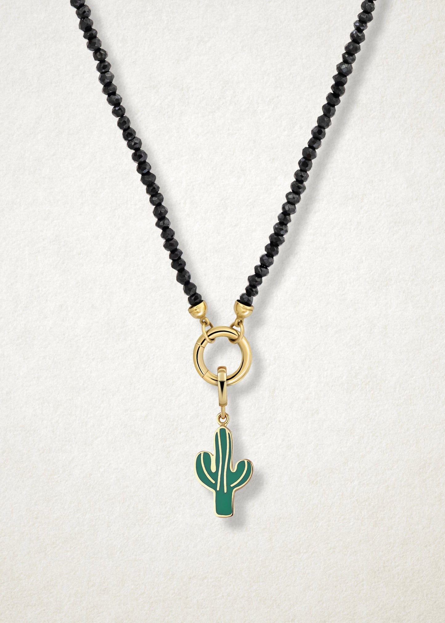 Close-up of the Desert Bloom Charm paired with the Noir Elegance Charm Necklace by whywhy NYC, featuring black spinel and 14K solid gold for a striking and botanical-inspired style.