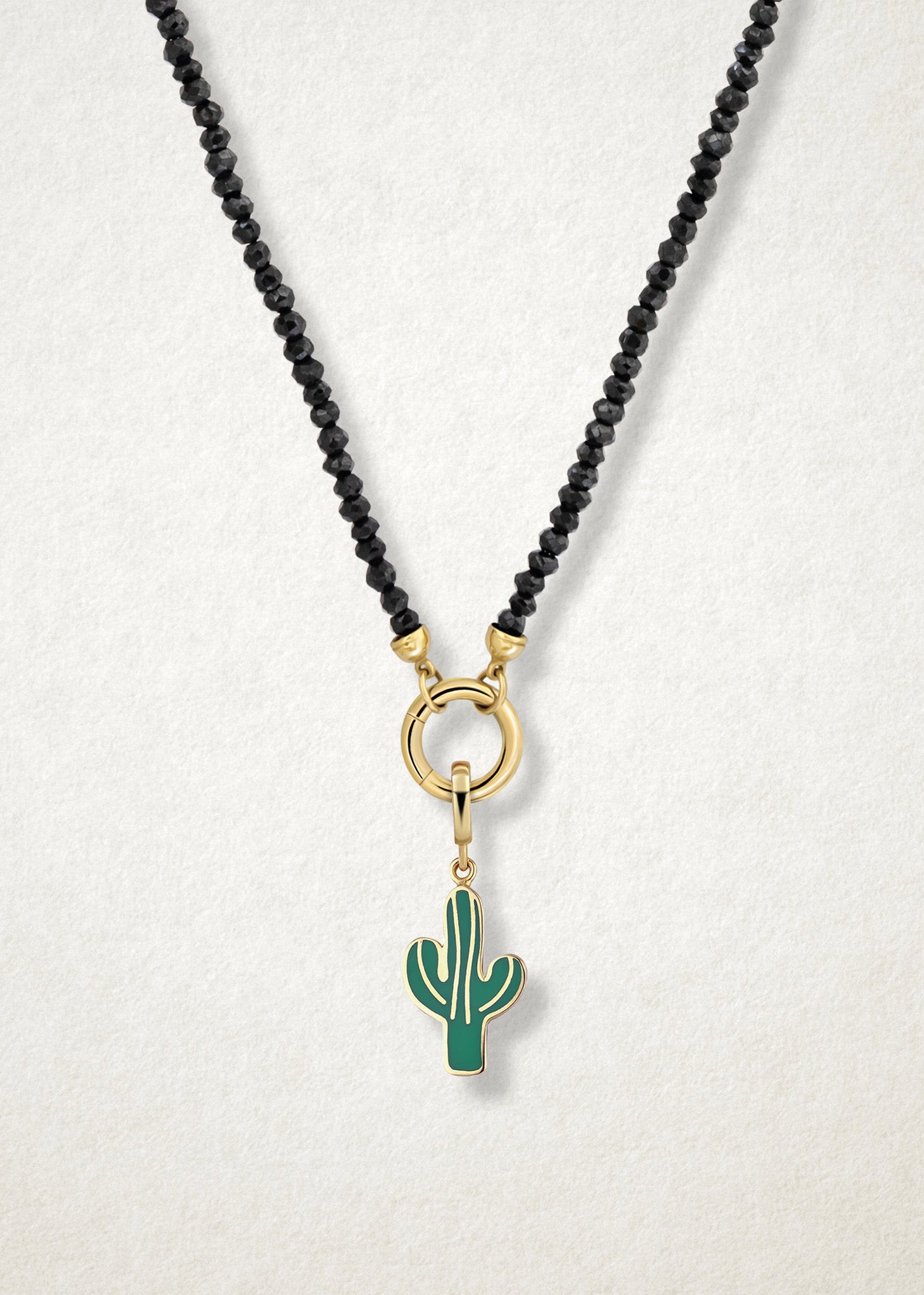 Close-up of the Desert Bloom Charm paired with the Noir Elegance Charm Necklace by whywhy NYC, featuring black spinel and 14K solid gold for a striking and botanical-inspired style.