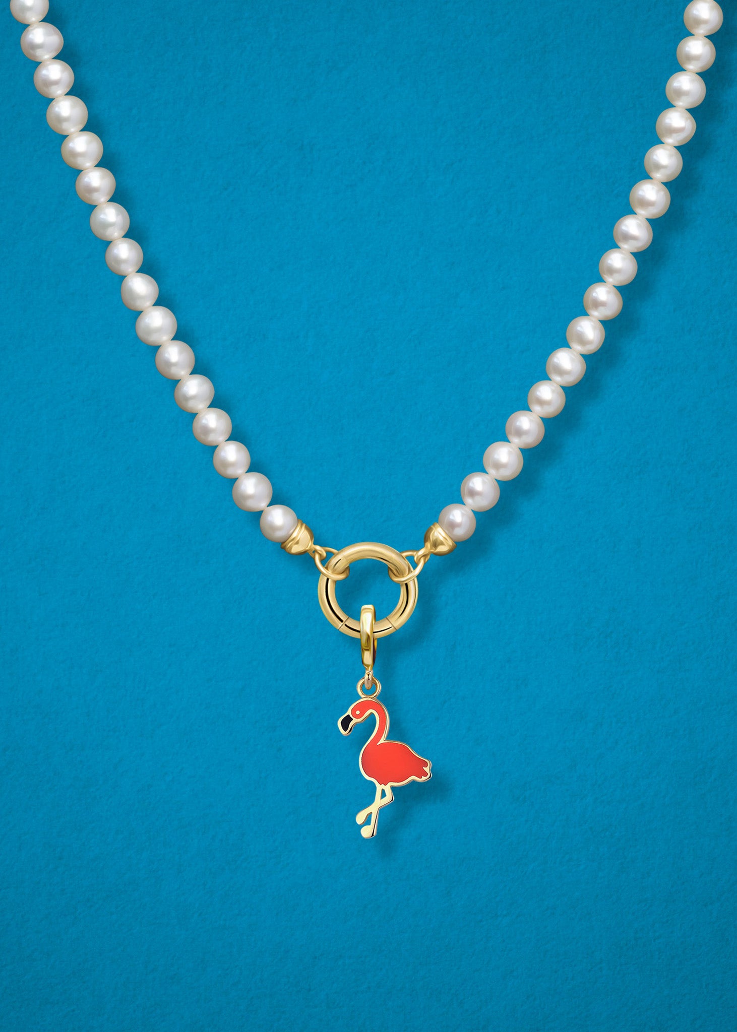 Close-up of the Flamingo Flair Charm paired with the Lustrous Pearl Charm Necklace by whywhy NYC, featuring 14K solid gold and freshwater pearls for an elegant and playful design.