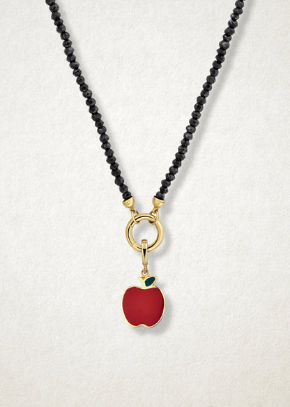 Close-up of the Golden Apple Charm paired with the Noir Elegance Charm Necklace by whywhy NYC, featuring black spinel and 14K solid gold for a striking and sophisticated design.
