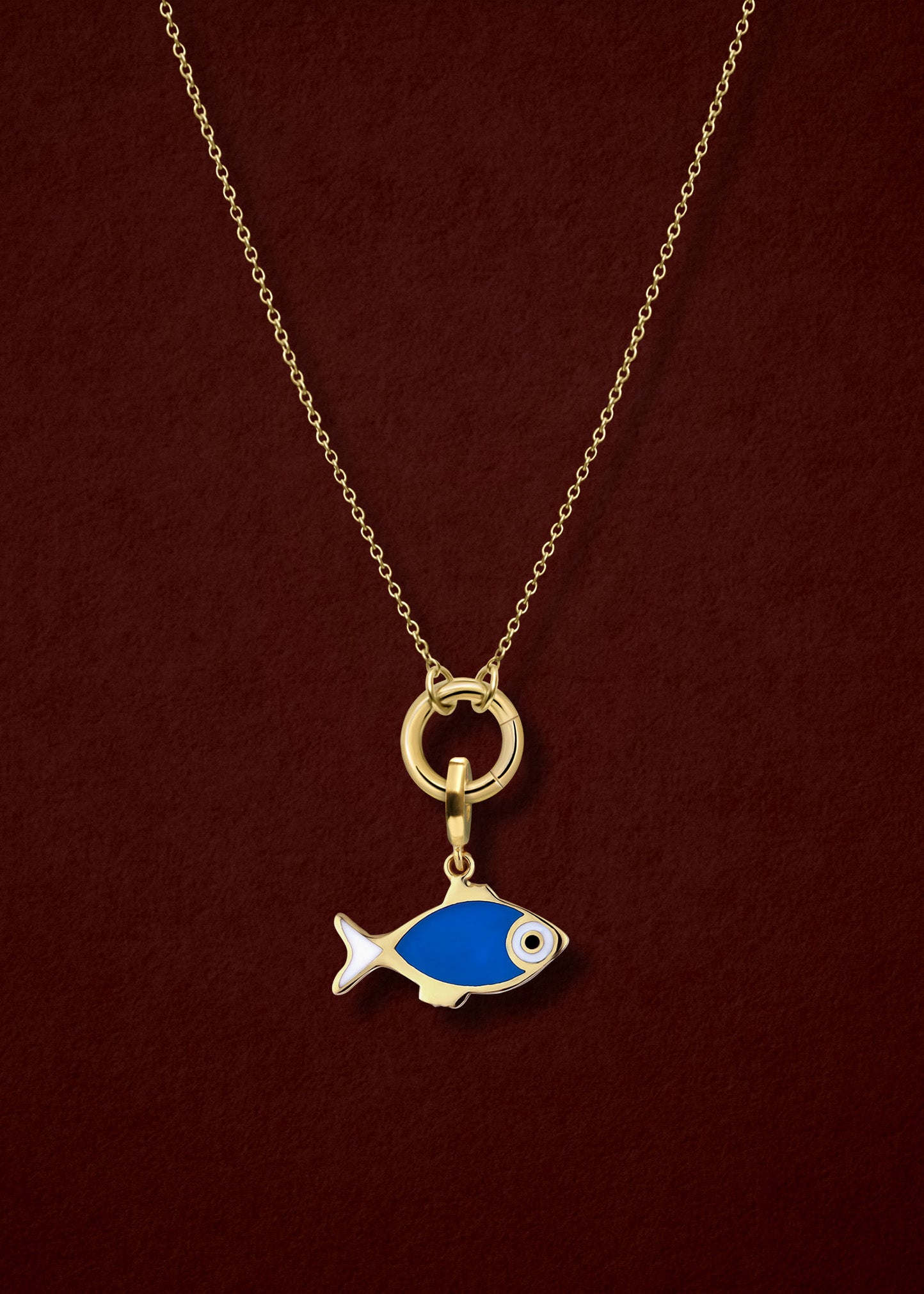 Close-up of the Golden Grace Fishy Wishes Charm Necklace, featuring a 14K solid gold cable chain, a golden charm holder, and a fishy wishes charm with vibrant enamel by whywhy NYC.
