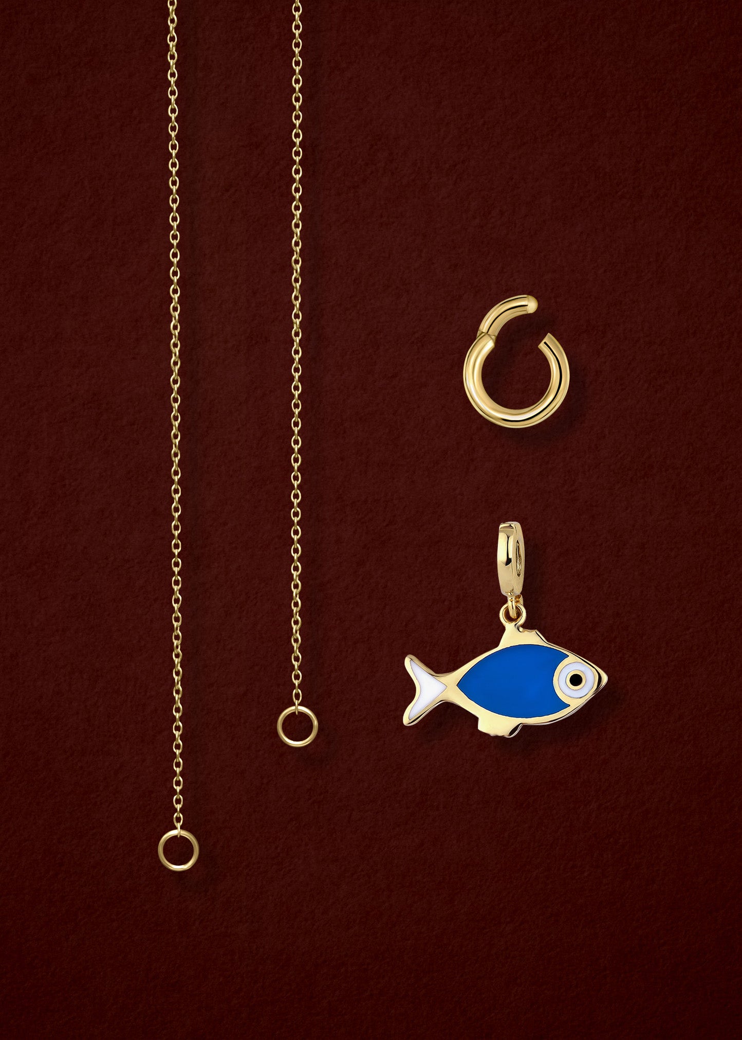 Close-up of the separated Golden Grace Fishy Wishes Charm Necklace components: 14K solid gold cable chain, golden charm holder, and fishy wishes charm with vibrant enamel by whywhy NYC.