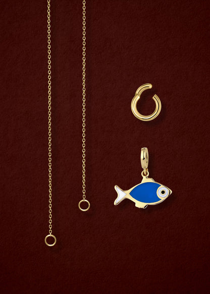 Close-up of the separated Golden Grace Fishy Wishes Charm Necklace components: 14K solid gold cable chain, golden charm holder, and fishy wishes charm with vibrant enamel by whywhy NYC.