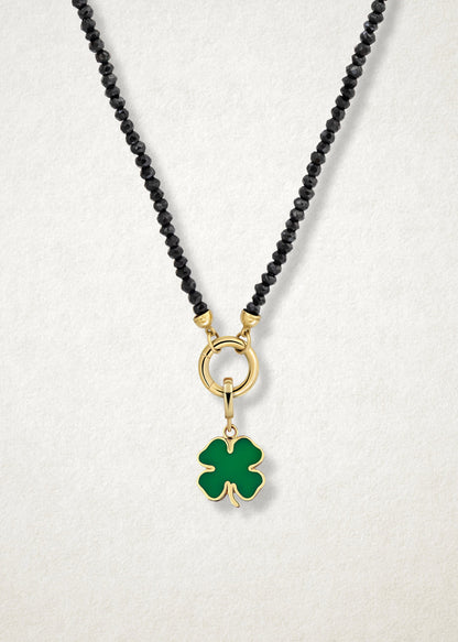 Close-up of the Lucky Clover Charm paired with the Noir Elegance Charm Necklace by whywhy NYC, featuring black spinel and 14K solid gold for a bold and unique statement.