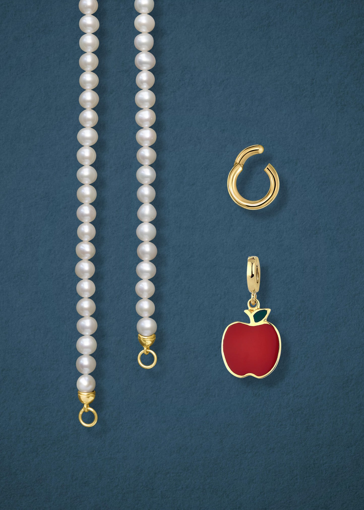 Close-up of the separated Lustrous Pearl Golden Apple of NYC Charm Necklace components: pearl necklace, golden link charm holder, and golden apple charm in 14K solid gold by whywhy NYC.
