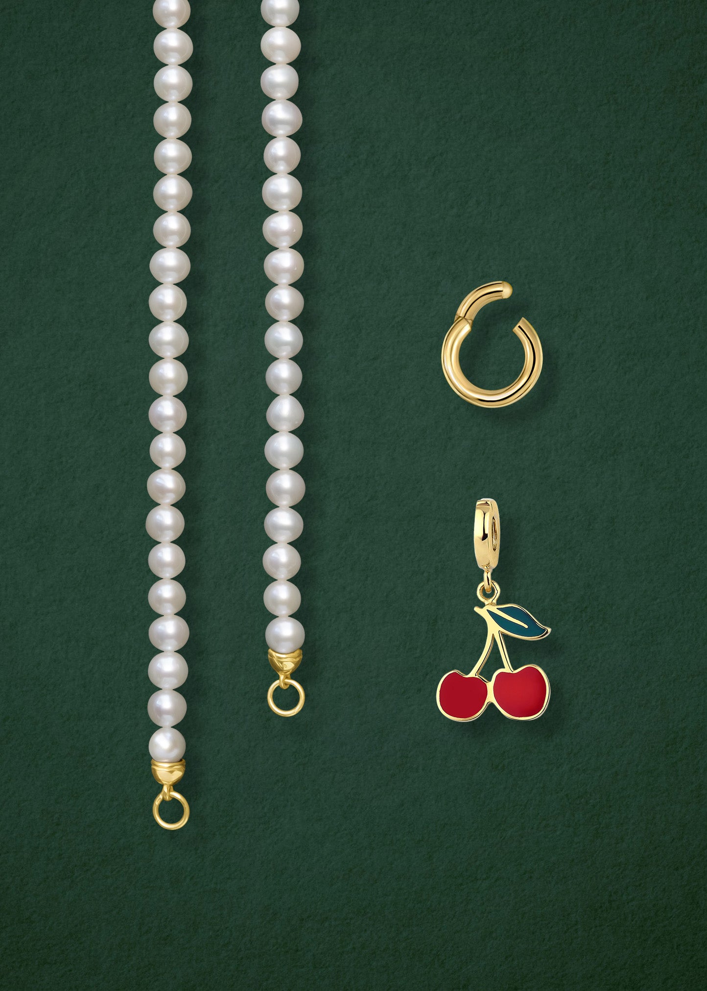 Close-up of the separated Lustrous Pearl Cherry on Top Charm Necklace components: pearl necklace, golden link charm holder, and cherry on top charm in 14K solid gold by whywhy NYC.