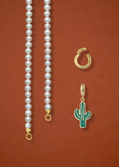 Close-up of the separated Lustrous Pearl Desert Bloom Charm Necklace components: pearl necklace, golden link charm holder, and desert bloom charm in 14K solid gold by whywhy NYC.