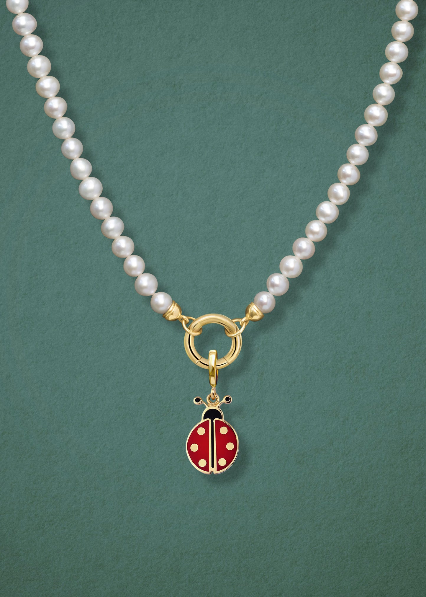 Close-up of the Lustrous Pearl Lucky Ladybird Charm Necklace, featuring freshwater pearls, a golden link charm holder, and a lucky ladybird charm in 14K solid gold by whywhy NYC.