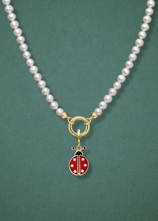 Close-up of the Lustrous Pearl Lucky Ladybird Charm Necklace, featuring freshwater pearls, a golden link charm holder, and a lucky ladybird charm in 14K solid gold by whywhy NYC.