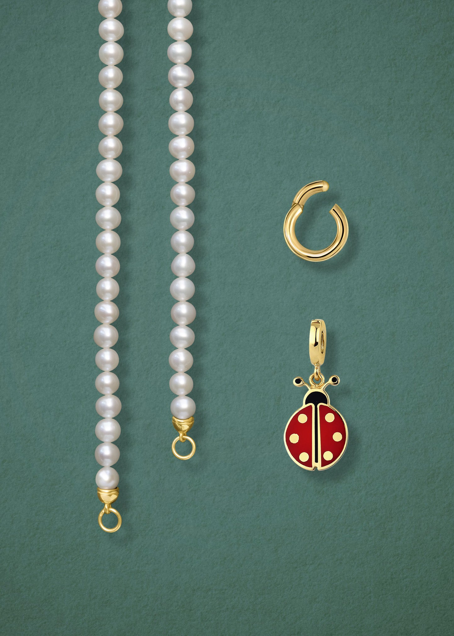 Close-up of the separated Lustrous Pearl Lucky Ladybird Charm Necklace components: pearl necklace, golden link charm holder, and lucky ladybird charm in 14K solid gold by whywhy NYC.