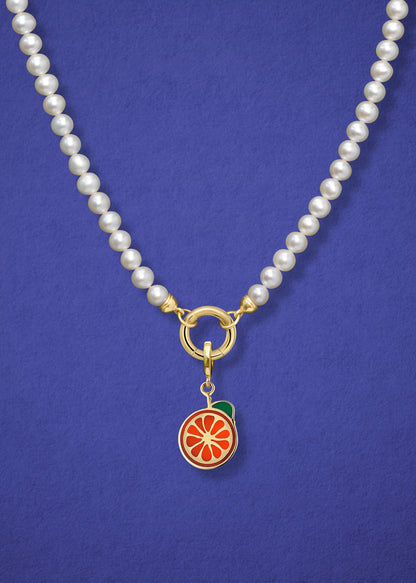 Close-up of the Lustrous Pearl Orange Crush Charm Necklace, featuring freshwater pearls, a golden link charm holder, and an orange crush charm in 14K solid gold by whywhy NYC.