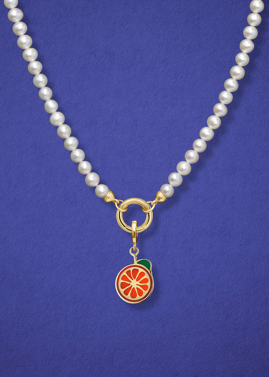 Close-up of the Lustrous Pearl Orange Crush Charm Necklace, featuring freshwater pearls, a golden link charm holder, and an orange crush charm in 14K solid gold by whywhy NYC.