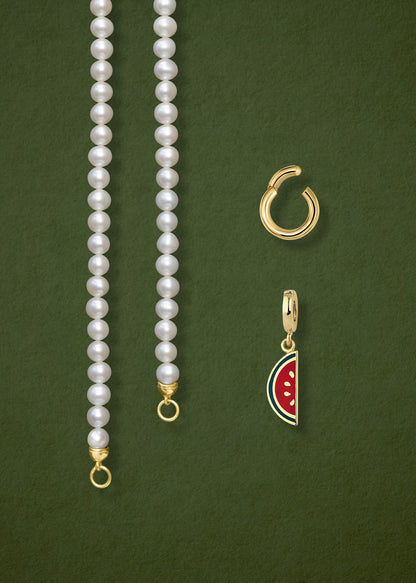 Close-up of the separated Lustrous Pearl Watermelon Wonder Charm Necklace components: pearl necklace, golden link charm holder, and watermelon wonder charm in 14K solid gold by whywhy NYC.