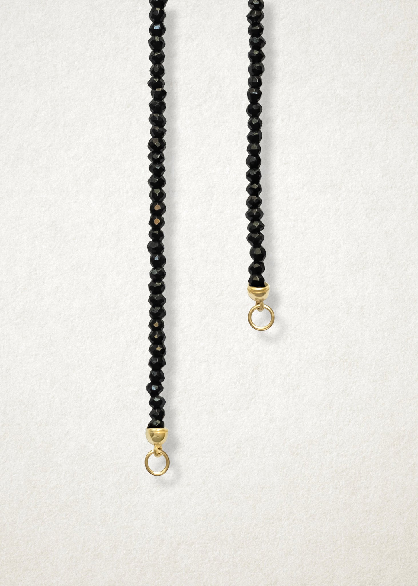 Close-up of the Noir Elegance Charm Necklace by whywhy NYC, featuring faceted black spinel rounds and a 14K solid gold clasp for a bold, refined design.