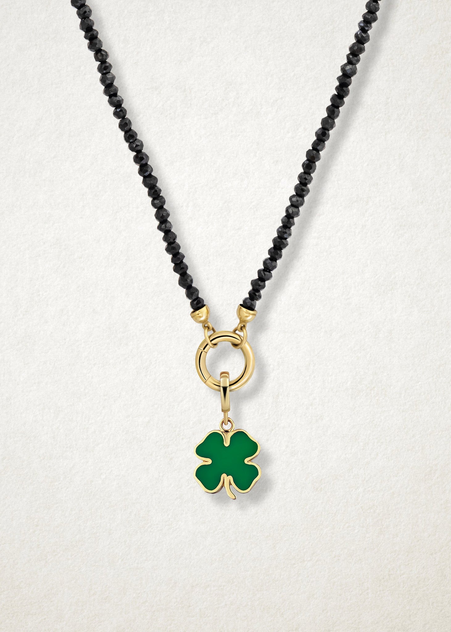 Close-up of the Noir Elegance Charm Necklace paired with the Lucky Clover Charm by whywhy NYC, featuring faceted black spinel and 14K solid gold for a bold and meaningful look.