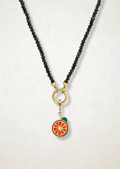 Close-up of the Orange Crush Charm paired with the Noir Elegance Charm Necklace by whywhy NYC, featuring black spinel and 14K solid gold for a bold and citrus-inspired style.