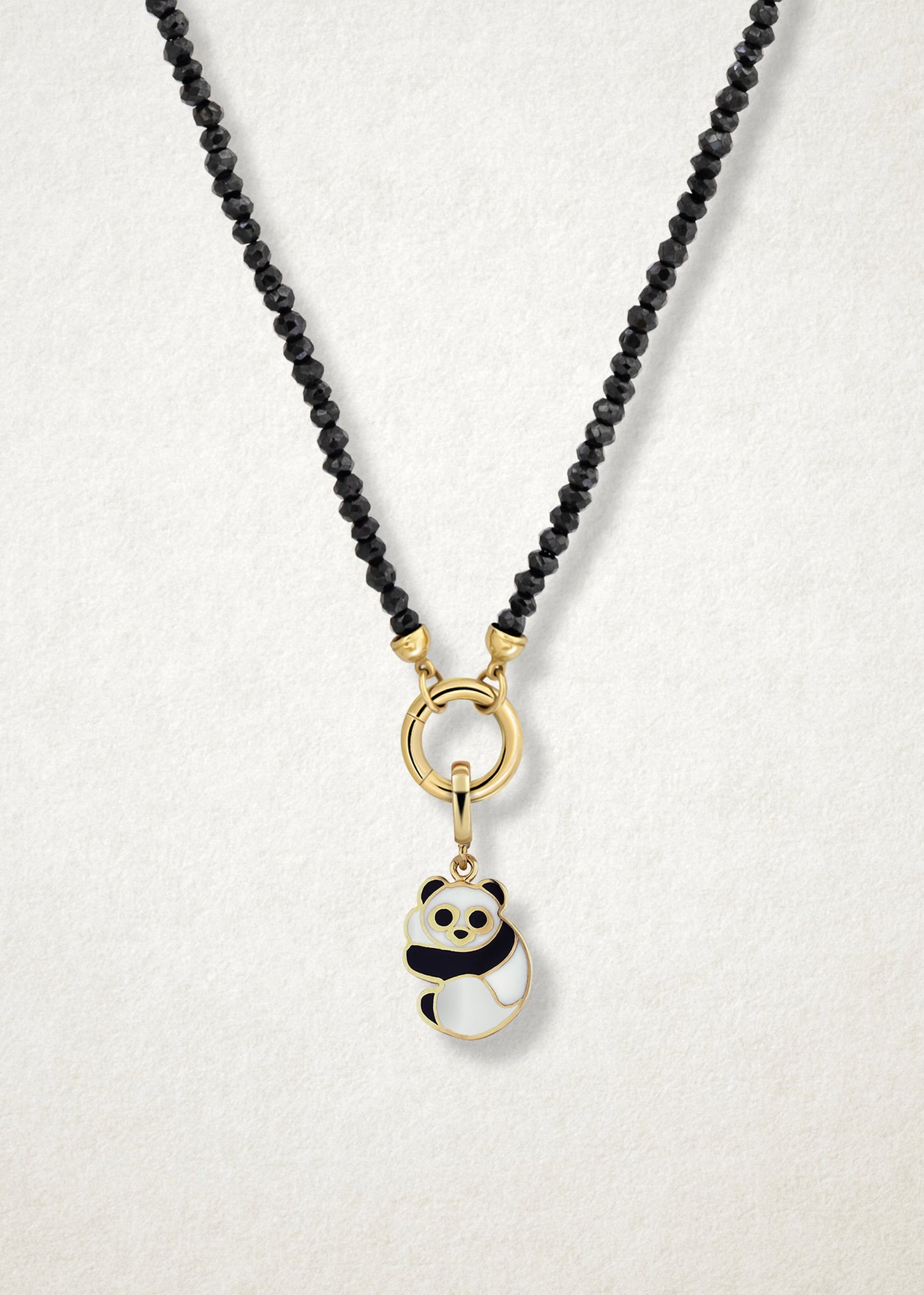 Close-up of the Panda Pals Charm paired with the Noir Elegance Charm Necklace by whywhy NYC, featuring black spinel and 14K solid gold for a bold and playful combination.
