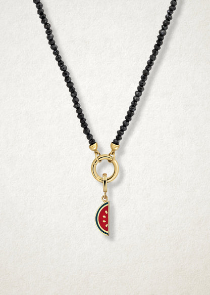 Close-up of the Watermelon Wonder Charm paired with the Noir Elegance Charm Necklace by whywhy NYC, featuring black spinel and 14K solid gold for a bold and unique statement.