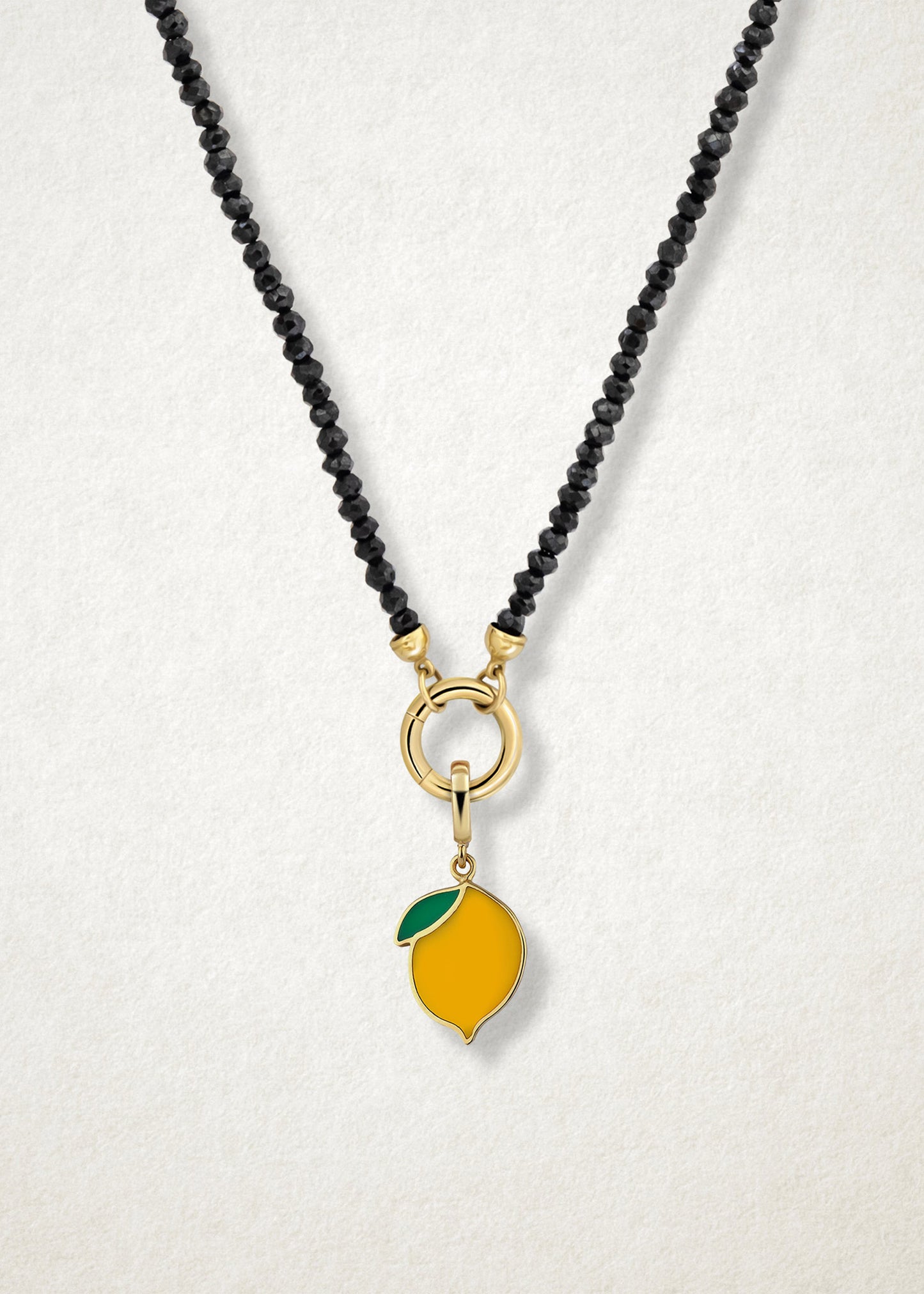 Close-up of the Zesty Lemon Charm paired with the Noir Elegance Charm Necklace by whywhy NYC, featuring black spinel and 14K solid gold for a bold and zesty touch.