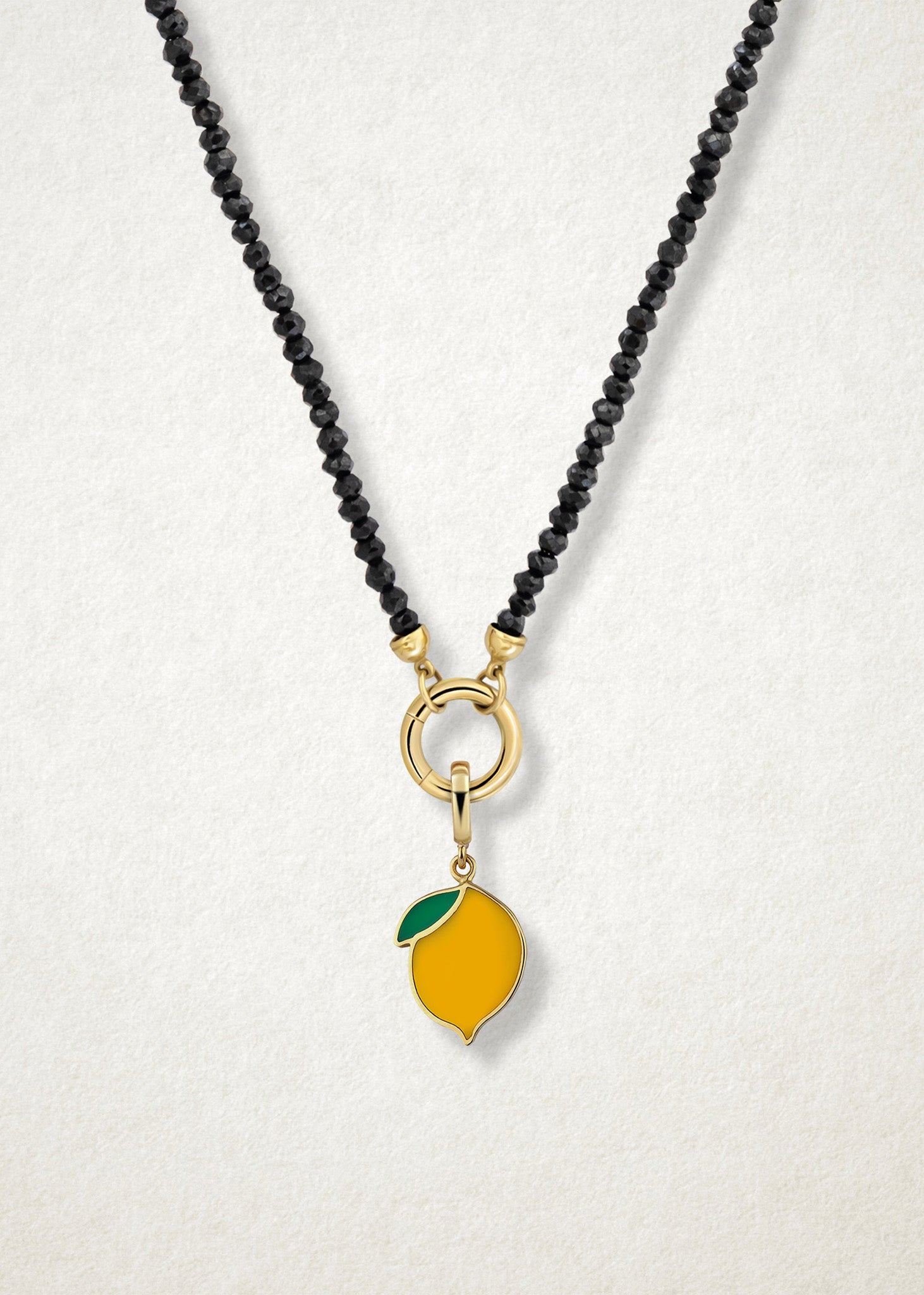 Close-up of the Zesty Lemon Charm paired with the Noir Elegance Charm Necklace by whywhy NYC, featuring black spinel and 14K solid gold for a bold and zesty touch.