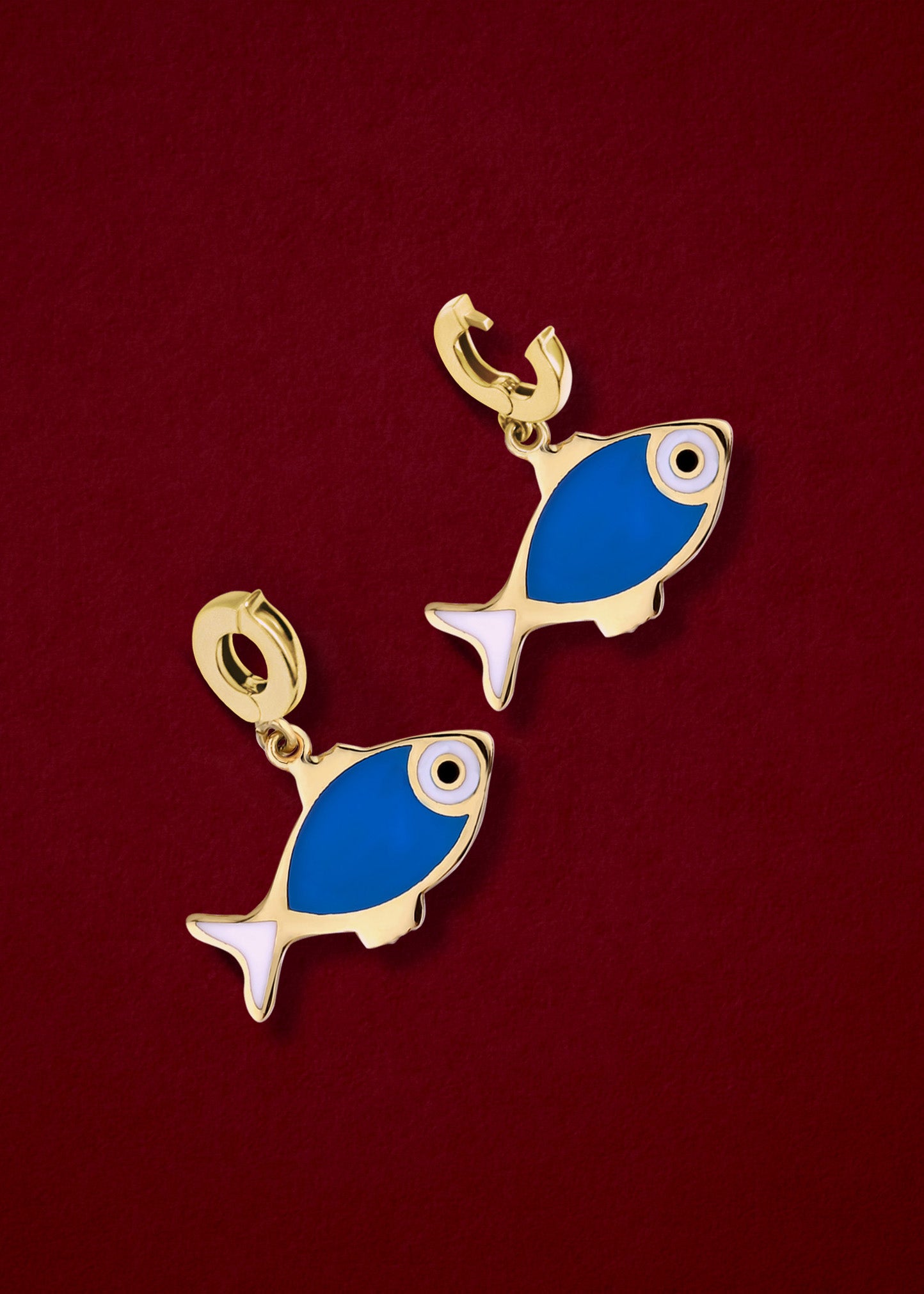 Fishy Wishes Charm showing both open and closed views of the 14K solid gold clip, with colorful enamel detail, displayed on a dark red background.