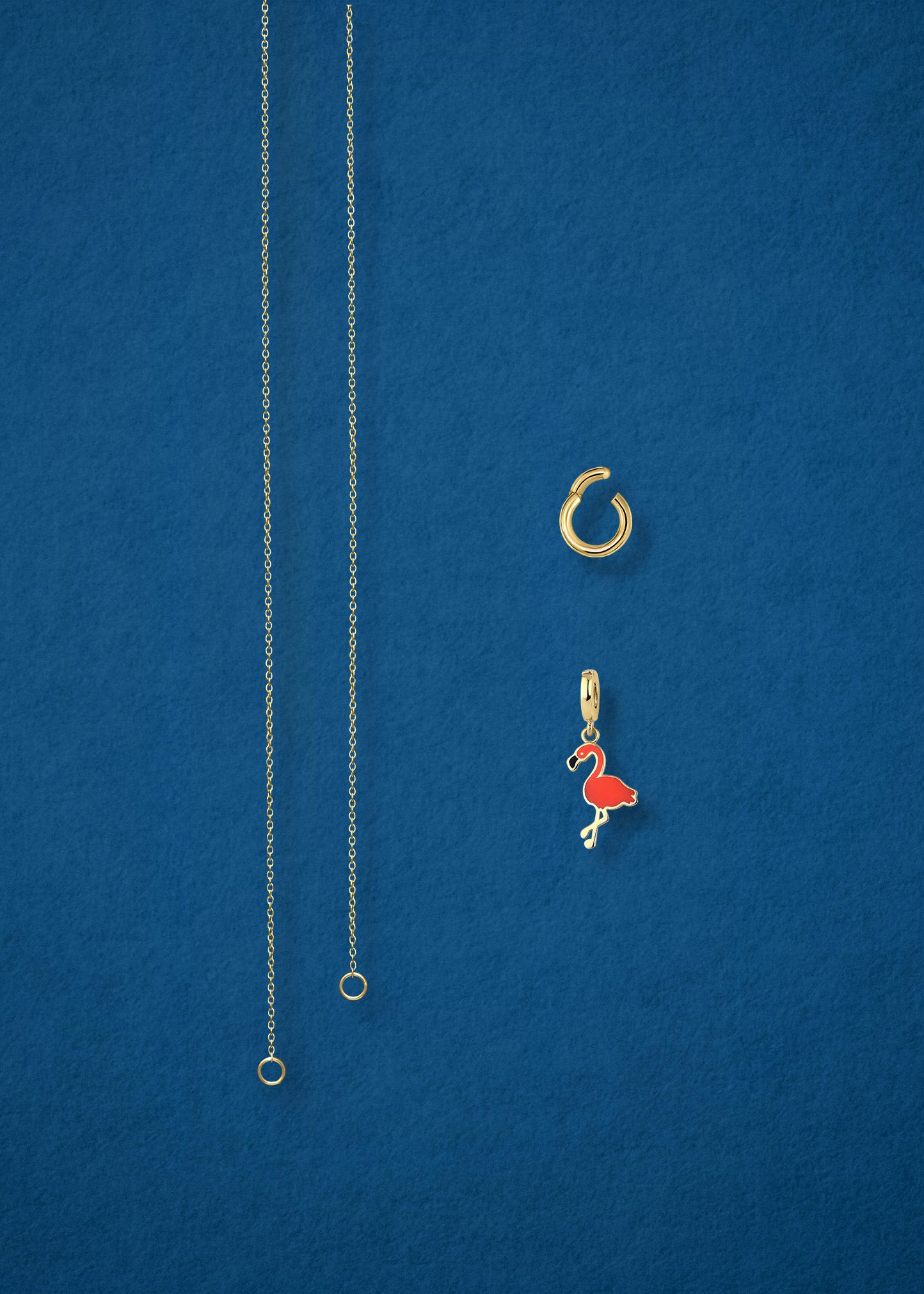 Separated components of the Golden Grace Flamingo Flair Charm Necklace, including 14K solid gold cable chain, golden charm holder, and flamingo flair charm with vibrant orange enamel by whywhy NYC.