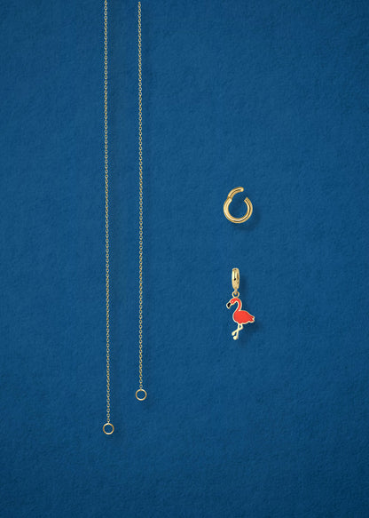 Separated components of the Golden Grace Flamingo Flair Charm Necklace, including 14K solid gold cable chain, golden charm holder, and flamingo flair charm with vibrant orange enamel by whywhy NYC.