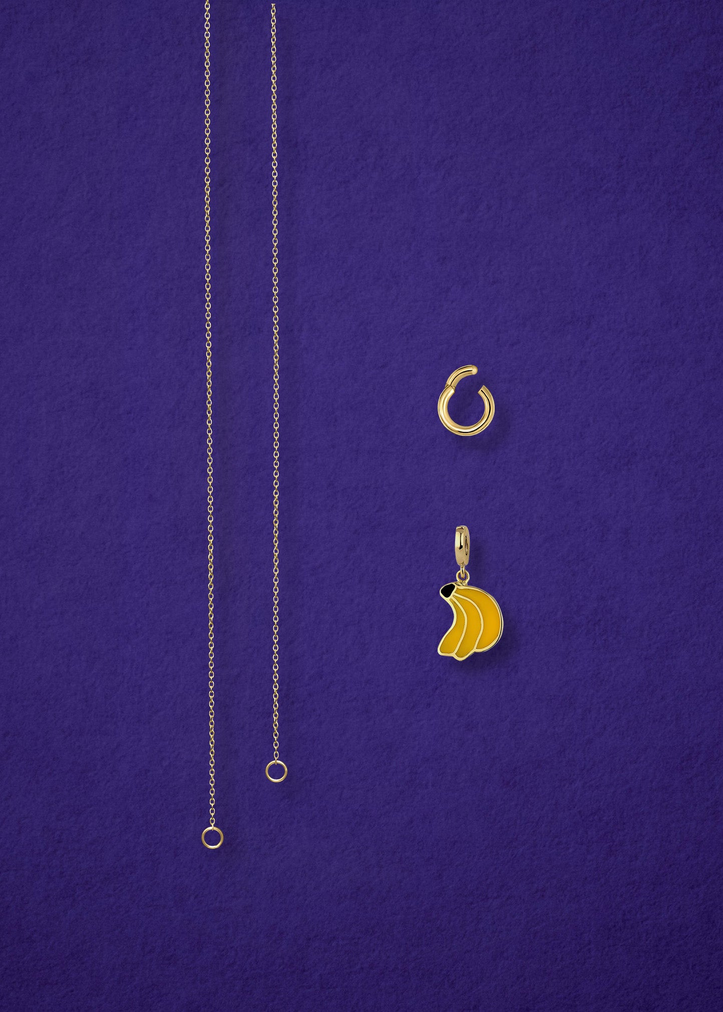 Separated components of the Golden Grace Banana Bliss Charm Necklace, including 14K solid gold cable chain, golden link charm holder, and banana bliss charm with yellow enamel by whywhy NYC.