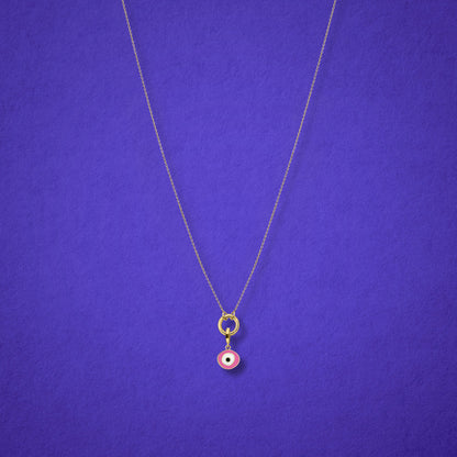 Blush Organic Evil Eye Charm with pink, white, and black enamel shown on the Golden Grace cable chain necklace for scale on a lilac background.