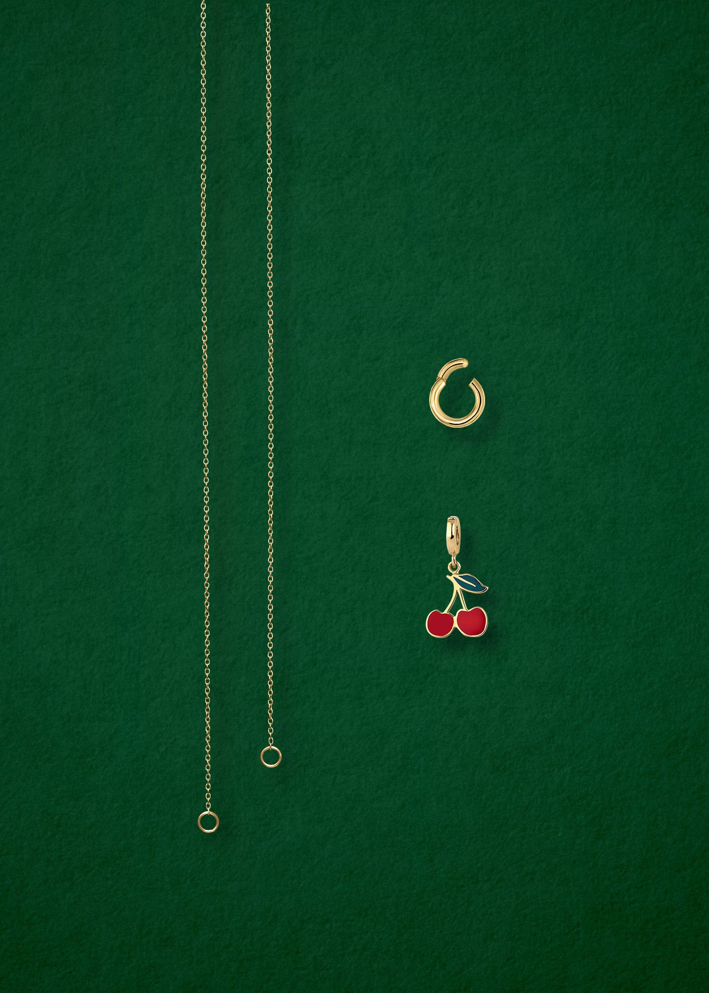 Separated components of the Golden Grace Cherry on Top Charm Necklace, including 14K solid gold cable chain, golden link charm holder, and cherry on top charm with red enamel by whywhy NYC.