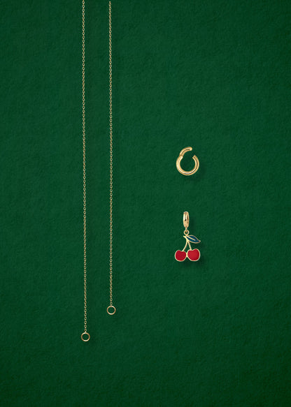 Separated components of the Golden Grace Cherry on Top Charm Necklace, including 14K solid gold cable chain, golden link charm holder, and cherry on top charm with red enamel by whywhy NYC.